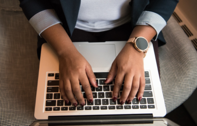 Photo of an office worker typing on a laptop