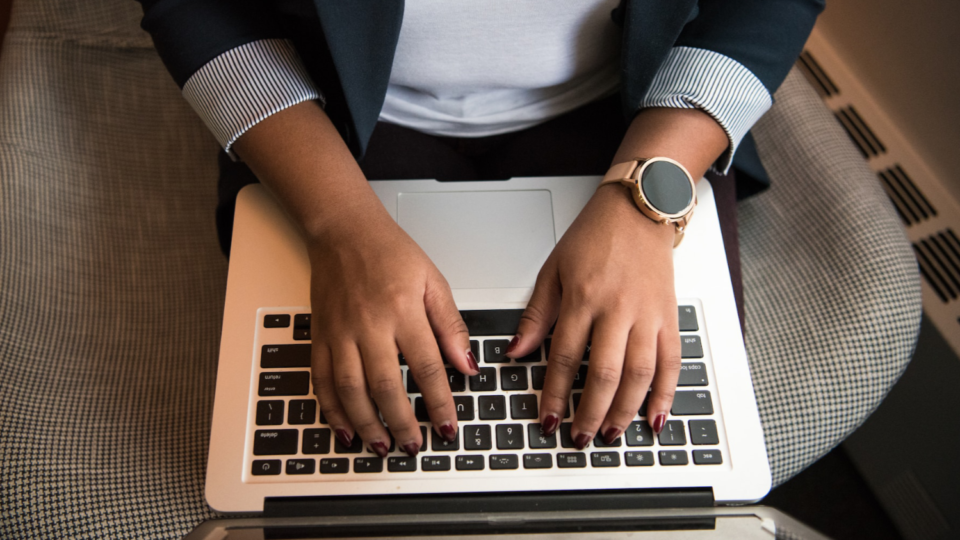 Photo of an office worker typing on a laptop