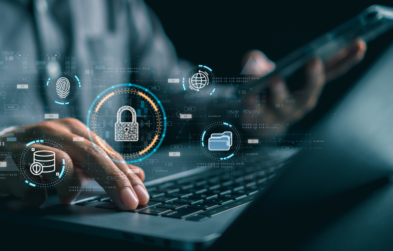 Photo of a person working on a laptop and holding a smartphone with cybersecurity-related icons in the foreground