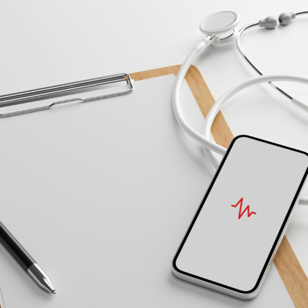 Stock photo of a clipboard, stethoscope, and smartphone displaying a heart rate icon