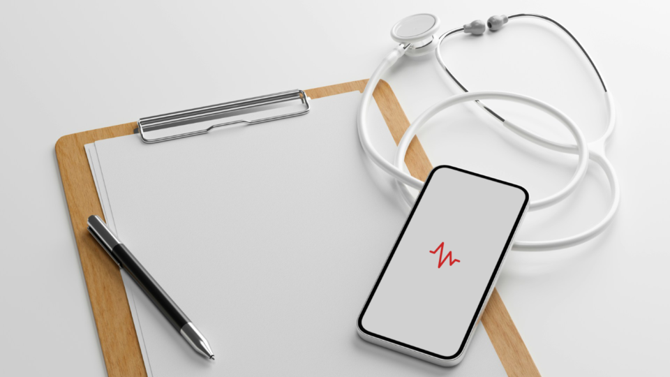 Stock photo of a clipboard, stethoscope, and smartphone displaying a heart rate icon