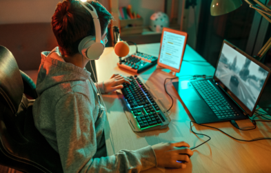 Teen boy playing video games at his computer.