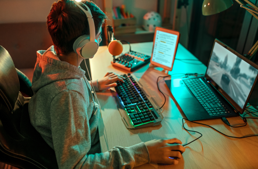 Teen boy playing video games at his computer.