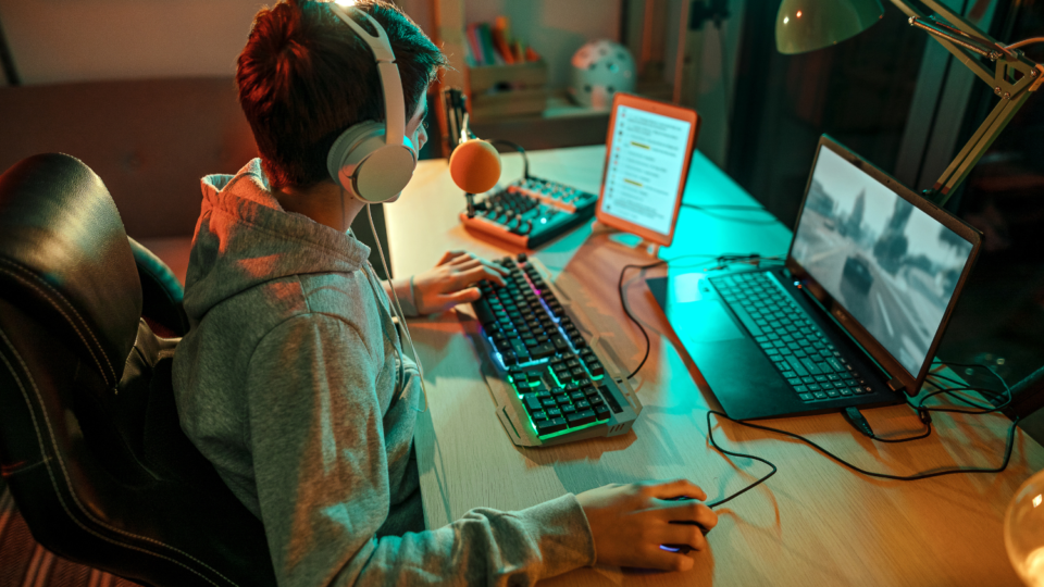 Teen boy playing video games at his computer.